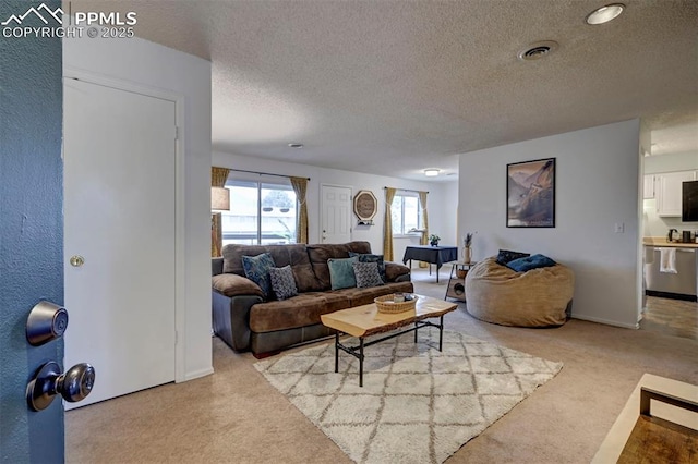 living room featuring a textured ceiling, carpet, and visible vents