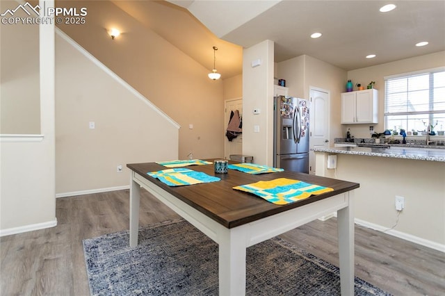 dining space with light wood-type flooring, baseboards, and recessed lighting