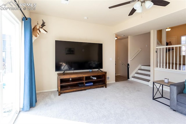 living area with a healthy amount of sunlight, stairs, and carpet flooring