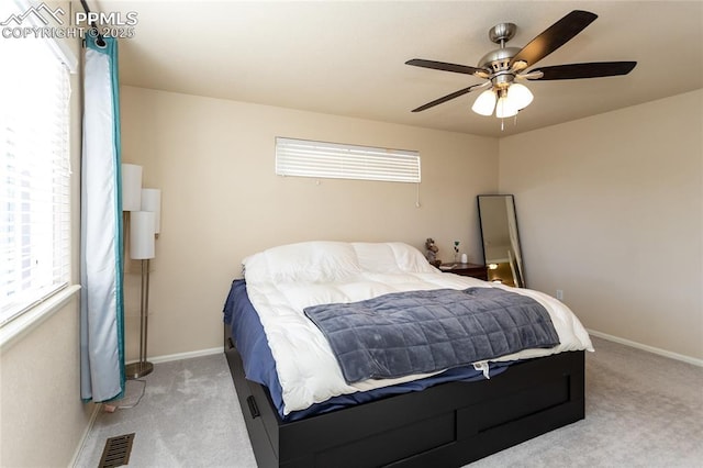 bedroom with light carpet, visible vents, and multiple windows