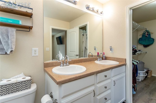 full bath with a sink, toilet, and double vanity