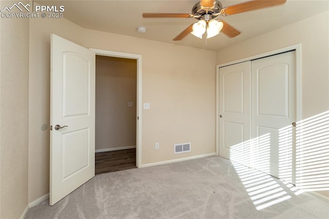 unfurnished bedroom featuring ceiling fan, carpet flooring, visible vents, baseboards, and a closet