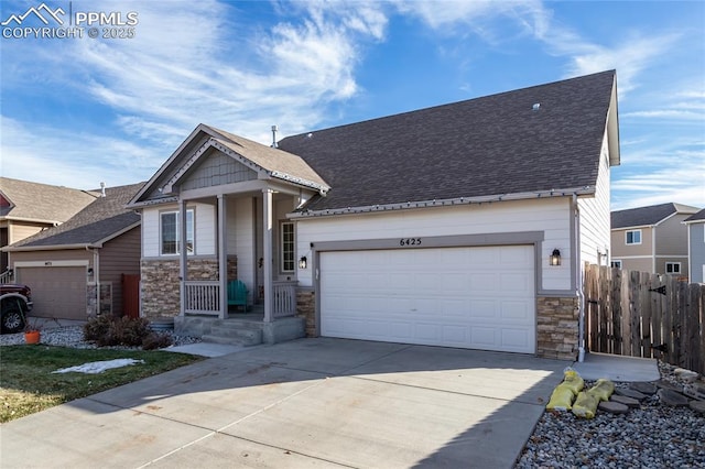 view of front of property featuring a garage, stone siding, and concrete driveway