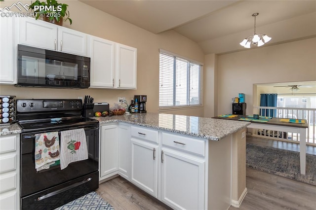 kitchen with light wood-style flooring, a peninsula, vaulted ceiling, black appliances, and white cabinetry