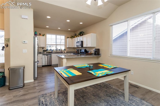 dining area with baseboards, wood finished floors, and recessed lighting