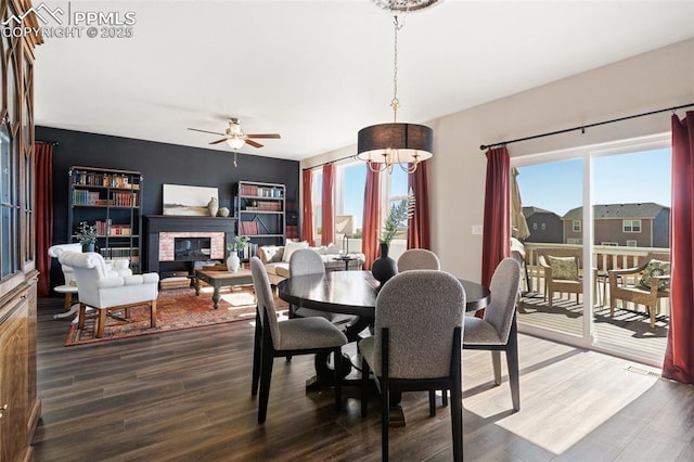 dining space with a healthy amount of sunlight, wood finished floors, and a glass covered fireplace