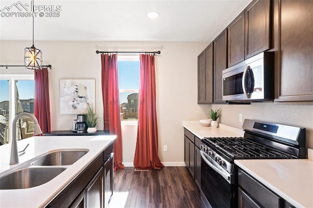 kitchen with appliances with stainless steel finishes, light countertops, and a sink