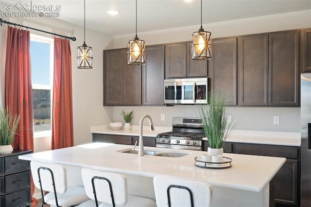 kitchen featuring stainless steel appliances, light countertops, a sink, and dark brown cabinets