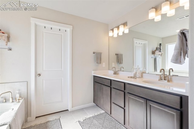 full bathroom with a bathing tub, tile patterned flooring, visible vents, and a sink