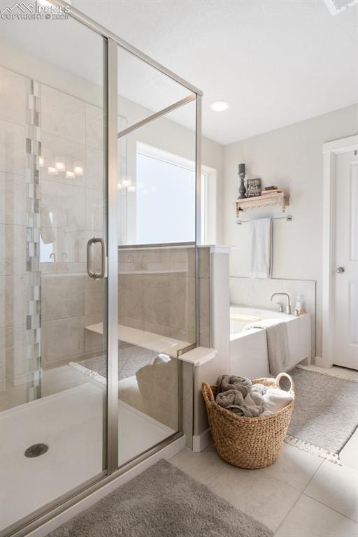 bathroom featuring tile patterned flooring, a shower stall, and a bath