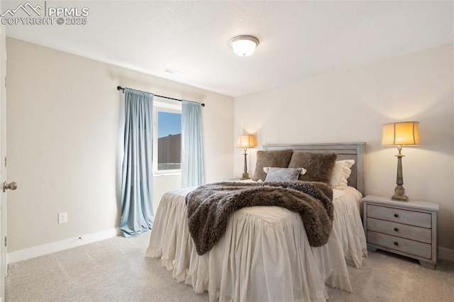 bedroom featuring light colored carpet and baseboards