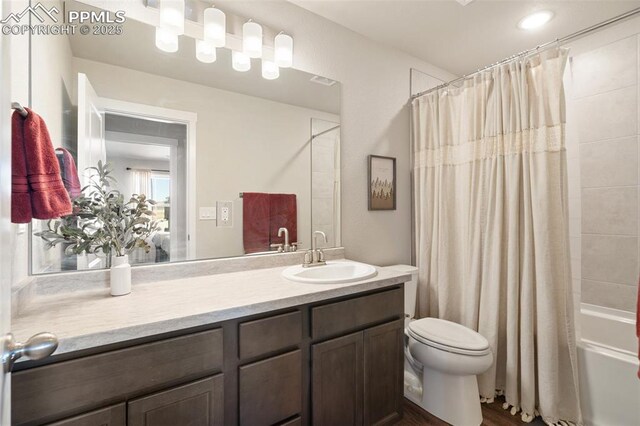 bathroom featuring shower / tub combo, vanity, and toilet