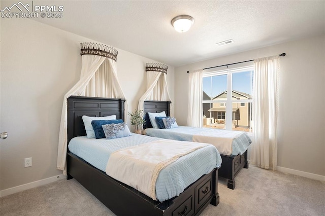 bedroom featuring baseboards, visible vents, a textured ceiling, and light colored carpet