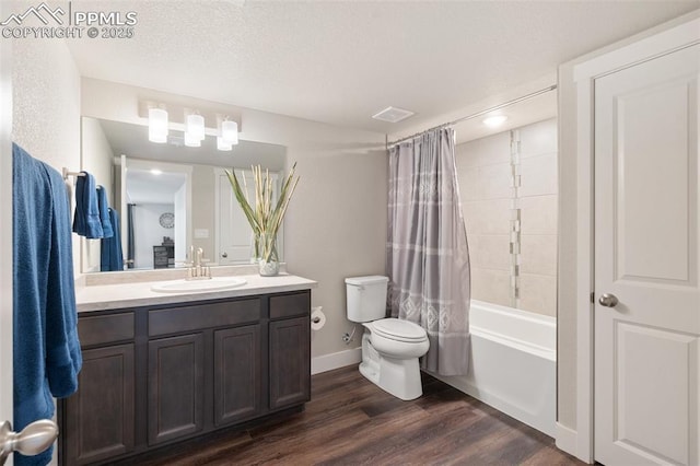 full bath featuring a textured ceiling, toilet, wood finished floors, vanity, and visible vents