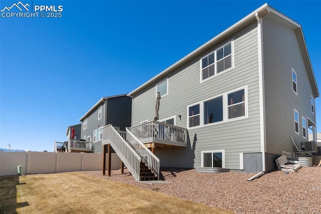 back of property with a lawn, stairway, fence, a deck, and central AC