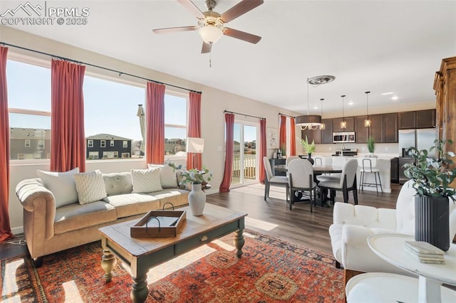 living area with baseboards, a ceiling fan, dark wood-type flooring, and recessed lighting