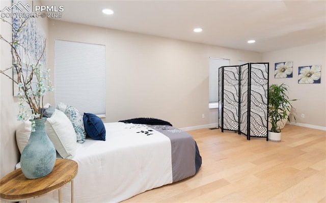 bedroom featuring baseboards, wood finished floors, and recessed lighting