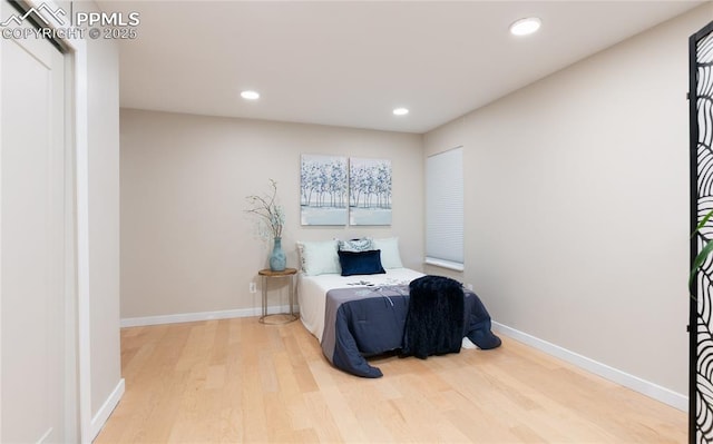 living area with recessed lighting, baseboards, and wood finished floors