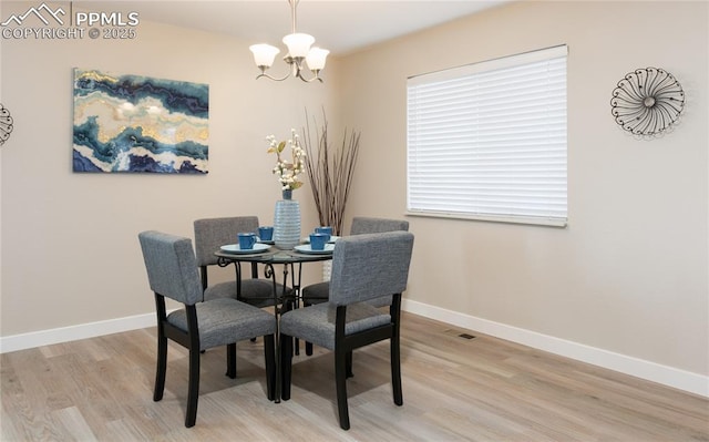 dining room featuring visible vents, a notable chandelier, light wood-style flooring, and baseboards