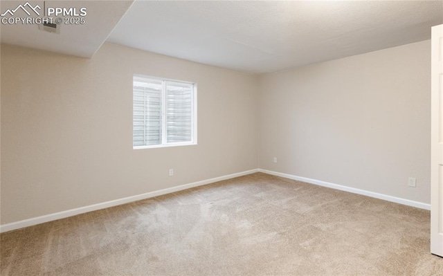 carpeted spare room featuring baseboards