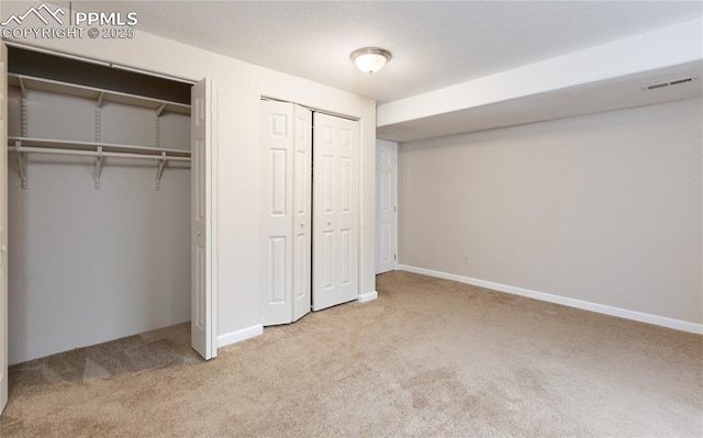 unfurnished bedroom featuring baseboards, visible vents, two closets, and carpet flooring