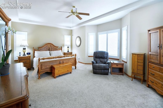 bedroom featuring carpet, baseboards, ceiling fan, and a tray ceiling