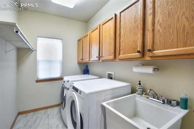 laundry room with cabinet space, baseboards, washer and clothes dryer, and a sink