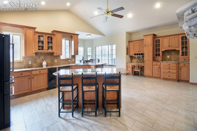 kitchen with a breakfast bar area, beverage cooler, a kitchen island, a sink, and tasteful backsplash