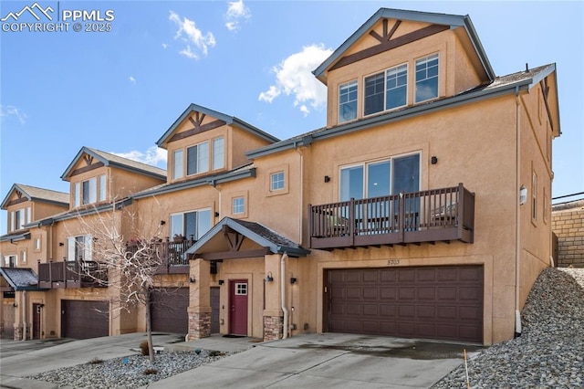 view of front of property featuring driveway, a balcony, an attached garage, and stucco siding