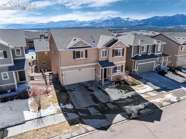 view of front of property featuring driveway, an attached garage, a residential view, and stucco siding