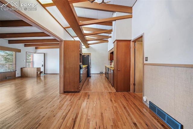 interior space with visible vents, light wood-style flooring, beam ceiling, and brown cabinetry