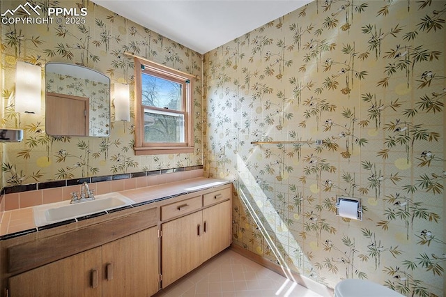 half bath with vanity, toilet, tile patterned flooring, and wallpapered walls