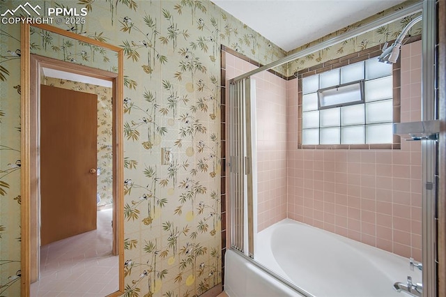 bathroom featuring wallpapered walls and combined bath / shower with glass door