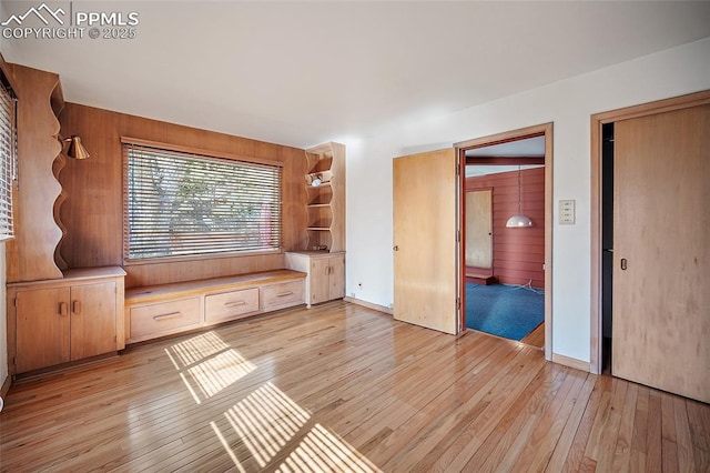 interior space featuring wood walls and light wood-style flooring