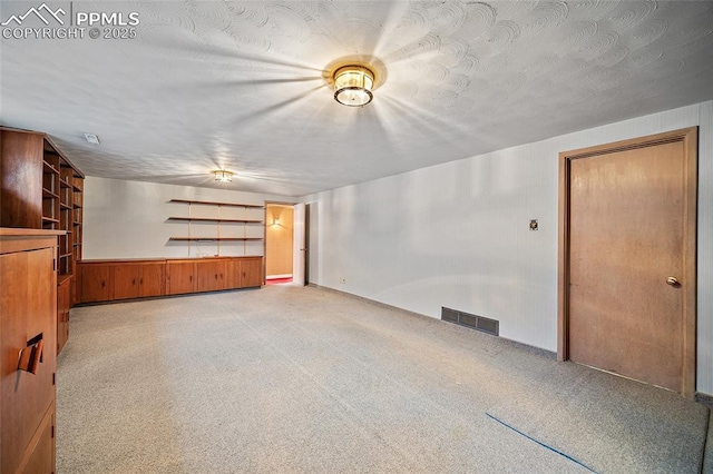 interior space with wooden walls, visible vents, and a wainscoted wall