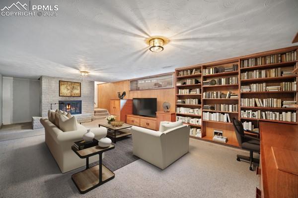 carpeted living room with a brick fireplace