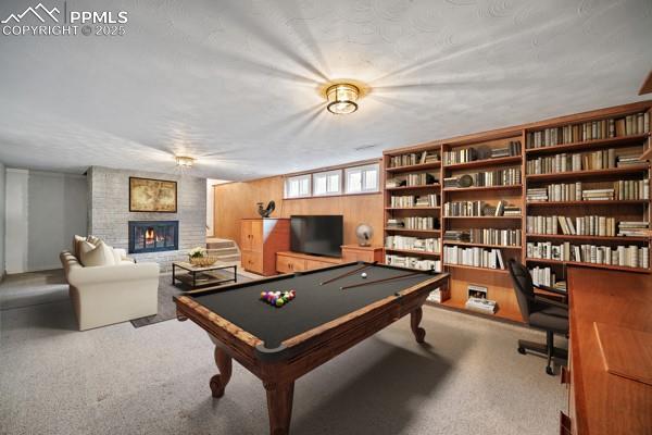 recreation room with carpet flooring, pool table, and a fireplace
