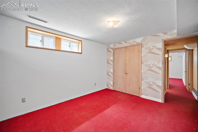 unfurnished bedroom with visible vents, carpet floors, and a textured ceiling
