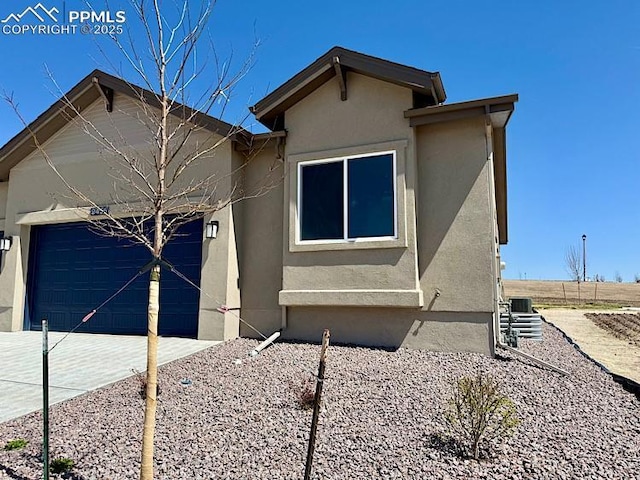 9455 Jollity Pt, Colorado Springs, CO 80924 - view of home's exterior with a garage, stucco siding, and concrete driveway
