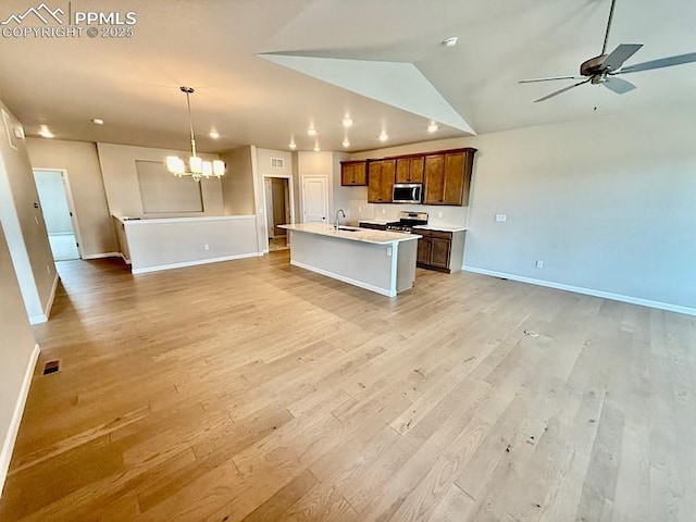 9455 Jollity Pt, Colorado Springs, CO 80924 - kitchen featuring appliances with stainless steel finishes, open floor plan, baseboards, ceiling fan, and vaulted ceiling