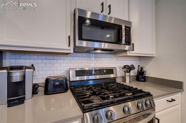 kitchen with light countertops, appliances with stainless steel finishes, backsplash, and white cabinetry