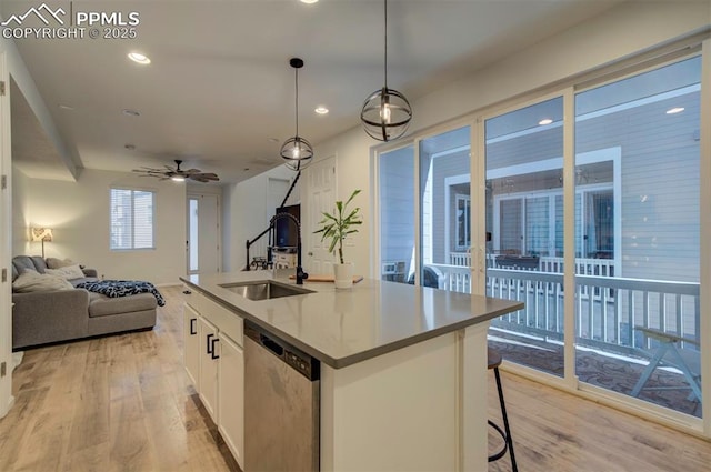 kitchen featuring a sink, light wood-style floors, open floor plan, white cabinets, and stainless steel dishwasher