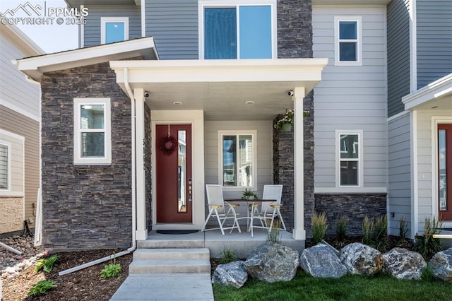 property entrance featuring covered porch and stone siding