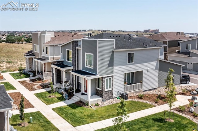 view of front facade featuring a shingled roof, central AC unit, a front yard, a residential view, and stone siding