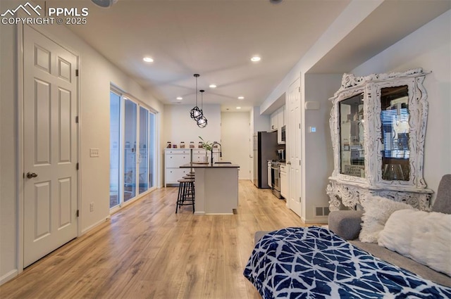 bedroom featuring recessed lighting, a sink, visible vents, light wood-type flooring, and freestanding refrigerator