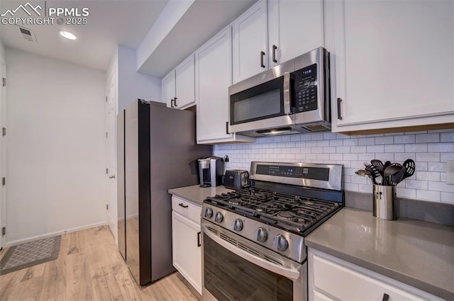 kitchen featuring visible vents, light wood-style flooring, backsplash, appliances with stainless steel finishes, and white cabinets