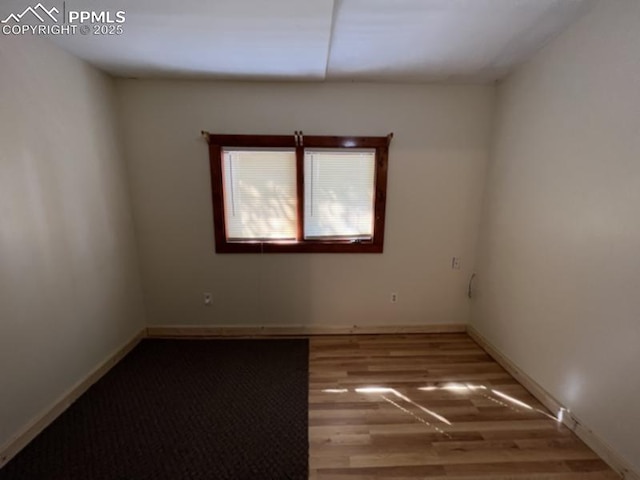 empty room featuring baseboards and wood finished floors