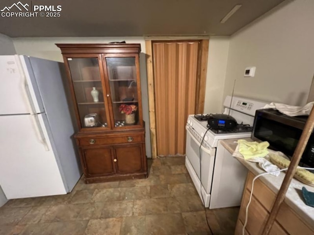 kitchen with glass insert cabinets, white appliances, and stone finish flooring