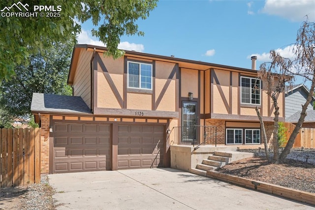 view of front of property featuring driveway, stucco siding, fence, and brick siding