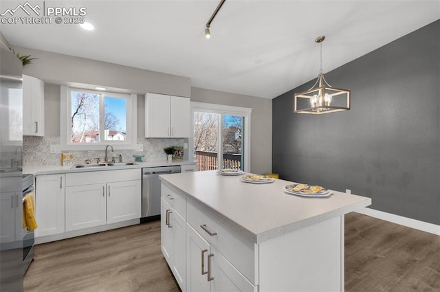 kitchen with light wood-type flooring, light countertops, a sink, and dishwasher